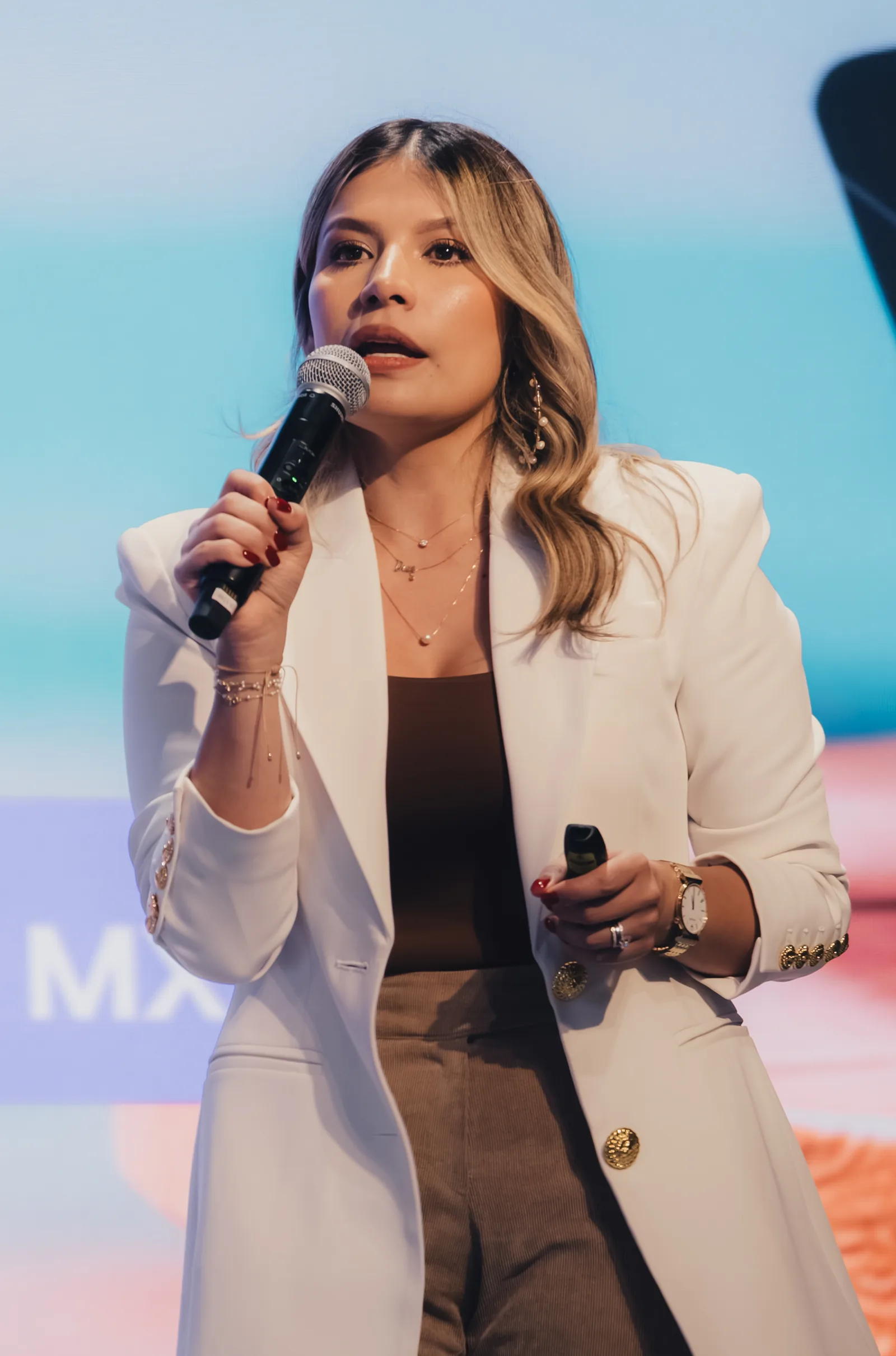 Presentación con micrófono en la tarima del evento de brokers