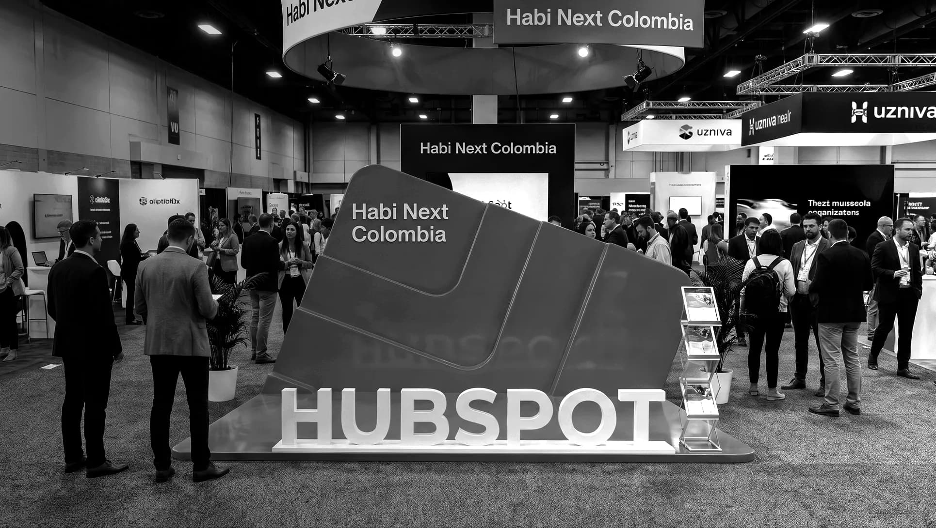 Zona de stands de Habi Next Colombia con asistentes conversando